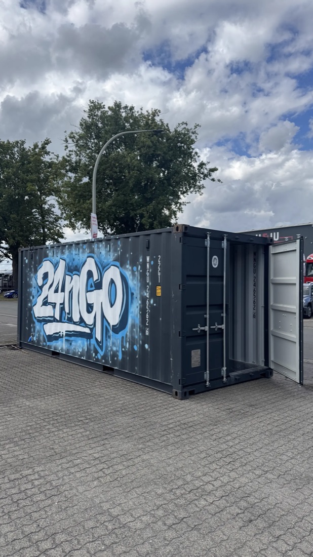 Outdoor-Container mit blauem 24nGo-Graffiti auf einem gepflasterten Platz